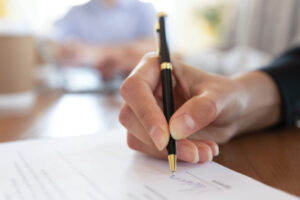 Writing signature on legal paperwork.