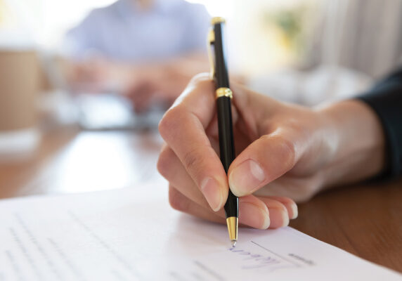 Writing signature on legal paperwork.